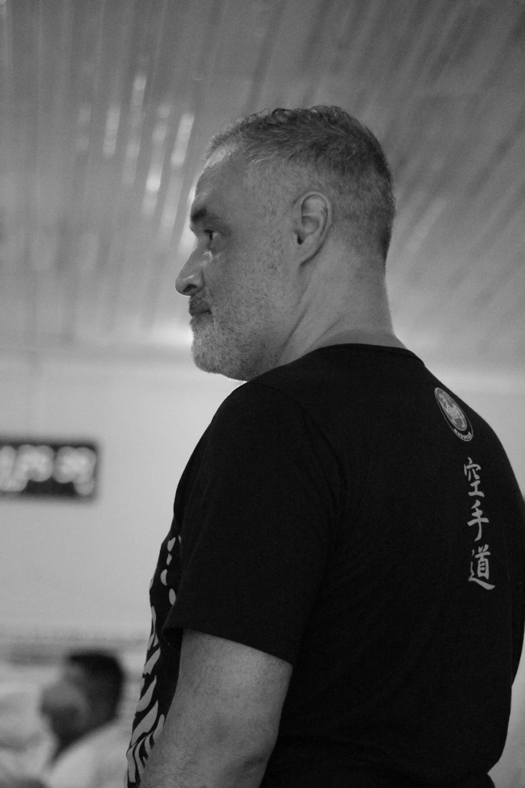 Retrato em preto e branco de Tulio Karam no dojo